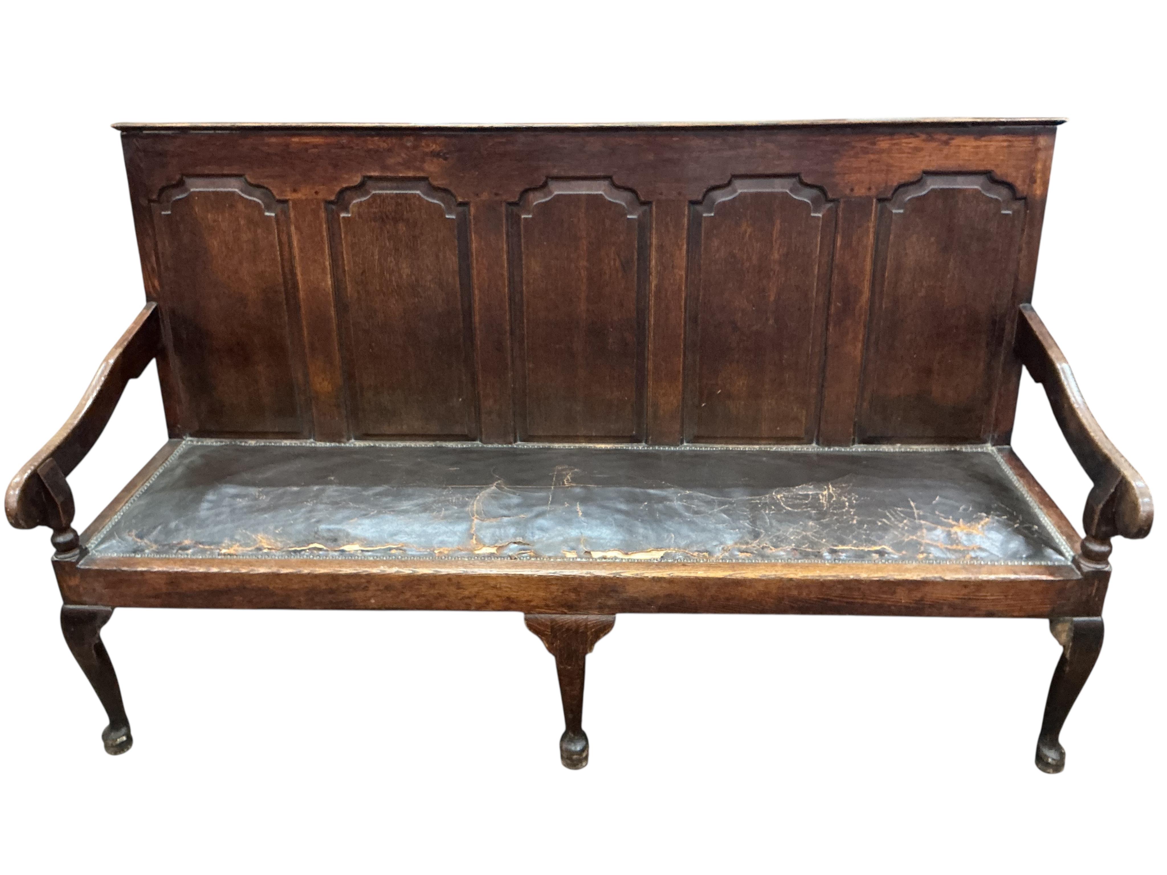 A George III panelled oak settle on cabriole front legs, width 185cm, depth 65cm, height 106cm